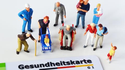 Gesundheitskarte mit menschlichen Figuren umgeben